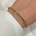 دستبند حلقه دار که در وسط آن زنجیر زرد و سفید است